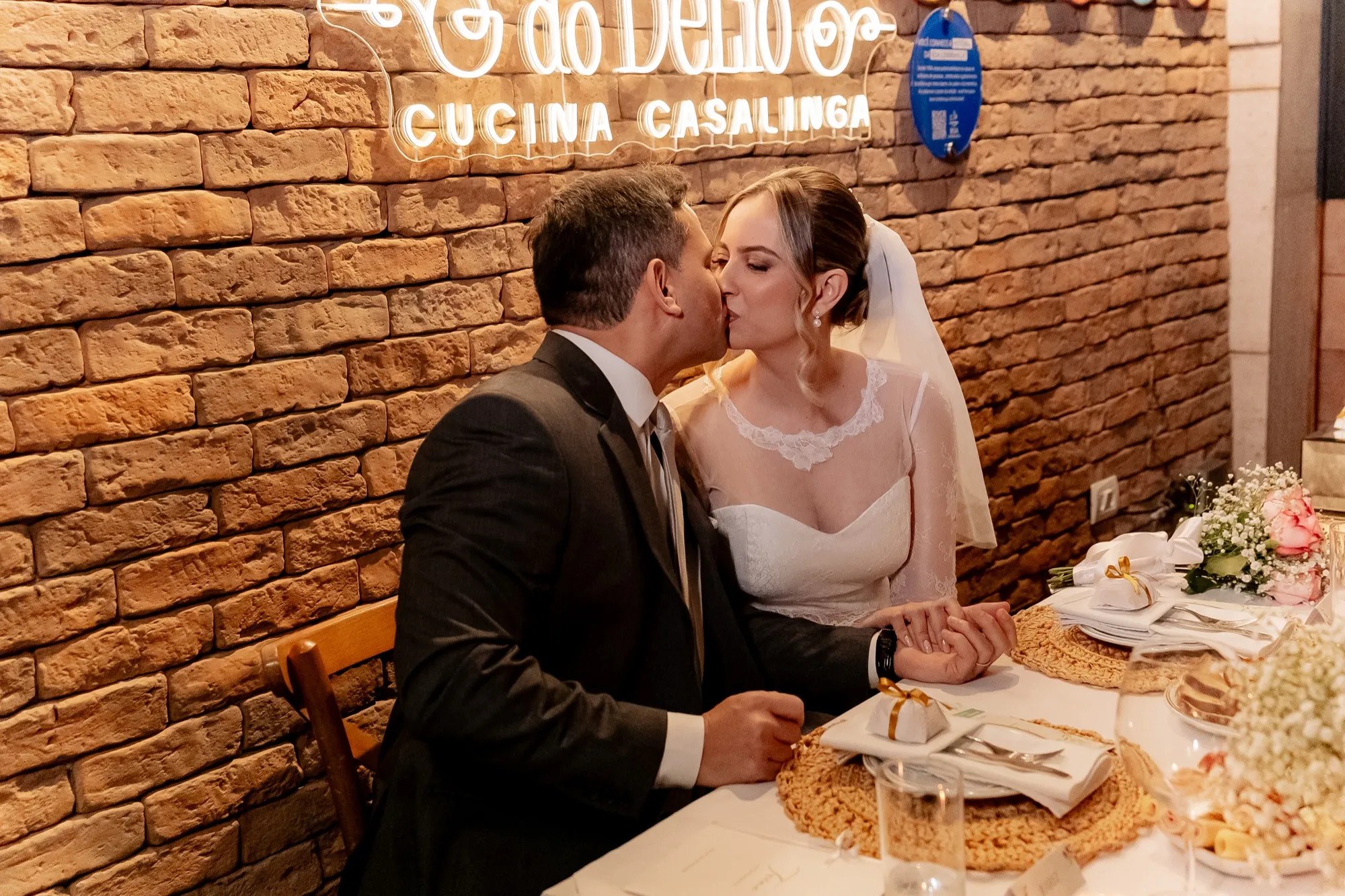 Os noivos se beijando à mesa
