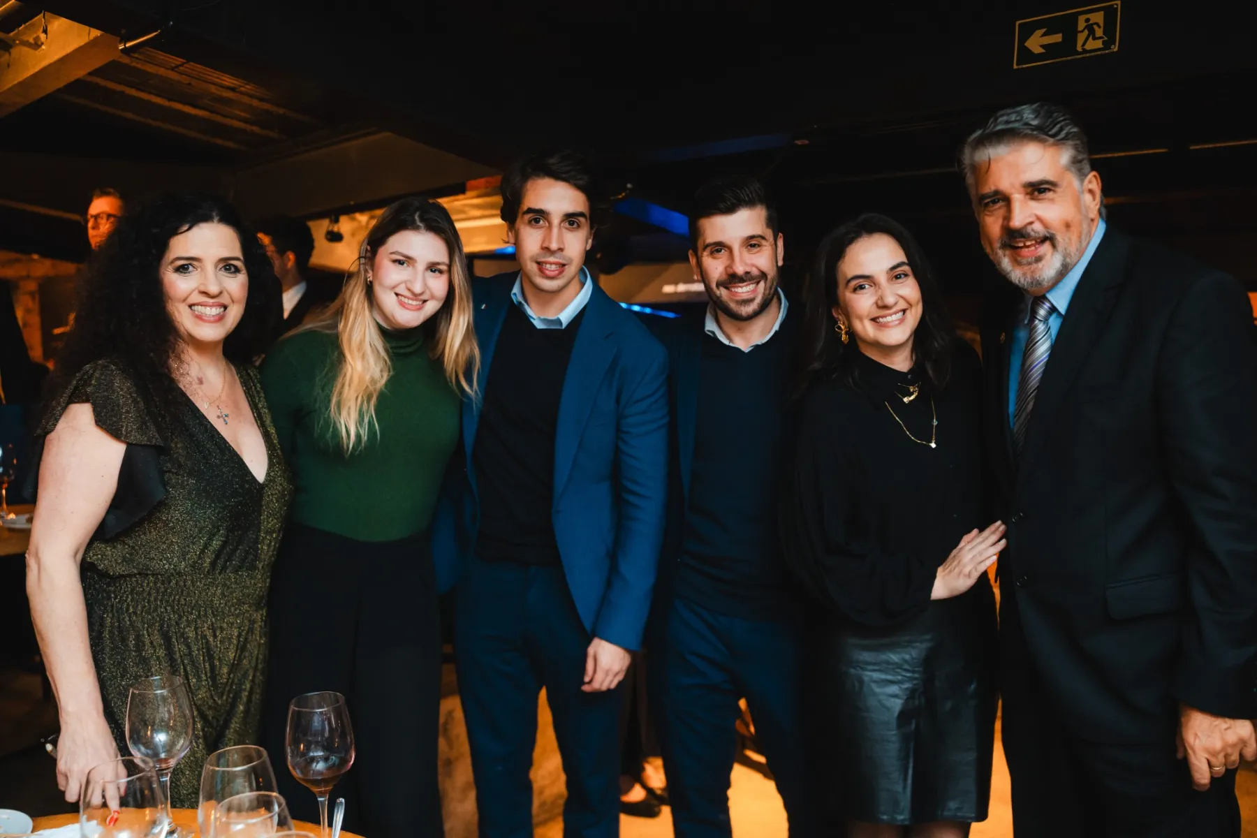 Seis pessoas abraçadas e sorrindo, com Délio à direita